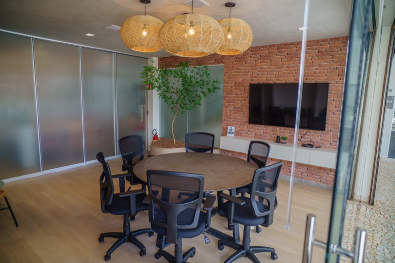 Sala de reunião da Via Sul Empresarial com mesa redonda, cadeiras e TV